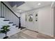 Inviting foyer boasts a beautiful front door with sidelights and stairway with black metal railings and light-colored wood-look floors at 768 Pinellas Point S Dr, St Petersburg, FL 33705