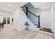 Foyer with tile flooring, staircase with dark wood railings, and views into dining area at 768 Pinellas Point S Dr, St Petersburg, FL 33705