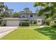 Charming two-story home with a well-manicured lawn, lush landscaping, and an attached two-car garage at 768 Pinellas Point S Dr, St Petersburg, FL 33705