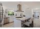 Modern kitchen featuring a center island, stainless steel appliances, and bright natural light at 768 Pinellas Point S Dr, St Petersburg, FL 33705