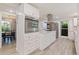 Kitchen with white cabinetry, stainless steel appliances, and views into the dining room at 768 Pinellas Point S Dr, St Petersburg, FL 33705