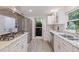 Kitchen with stainless steel appliances, granite countertops, white cabinets, and light gray tile flooring at 768 Pinellas Point S Dr, St Petersburg, FL 33705