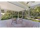 Enjoy the outdoors in this screened-in lanai with a neutral rug and views of the backyard's mature landscaping at 768 Pinellas Point S Dr, St Petersburg, FL 33705