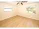 Bedroom featuring hardwood floors, two windows allowing ample sunlight, and neutral colored walls at 7904 Judith Cres, Port Richey, FL 34668