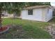 View of the home's front lawn and exterior showing stone accents, window and well-maintained landscaping at 7904 Judith Cres, Port Richey, FL 34668