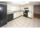 Updated kitchen featuring black appliances, light tile floor, and plentiful counter space and cabinet storage at 7904 Judith Cres, Port Richey, FL 34668