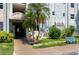 Entrance to building with landscaped lawn, bench, and shade trees at 801 83Rd N Ave # 209, St Petersburg, FL 33702