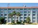 Exterior shot of a multi-story building with lawn and palm trees in front at 801 83Rd N Ave # 209, St Petersburg, FL 33702