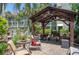 Comfortable outdoor patio with a wooden gazebo and cushioned seating surrounded by greenery at 801 83Rd N Ave # 209, St Petersburg, FL 33702