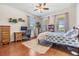 Bright bedroom featuring wood floors, a work station, and three large windows at 8296 Olive Brook Dr, Wesley Chapel, FL 33545