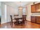An open dining room is brightly lit with a modern chandelier fixture and views of the backyard at 8296 Olive Brook Dr, Wesley Chapel, FL 33545