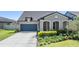 Well-maintained single-Gathering home with a two-car garage, landscaped front yard, and a welcoming entrance at 8296 Olive Brook Dr, Wesley Chapel, FL 33545