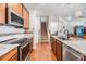 Kitchen with stone countertops and backsplash, stainless steel appliances, and wood floors at 8296 Olive Brook Dr, Wesley Chapel, FL 33545