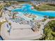 Stunning lagoon aerial view with sandy beach, palm trees, cabanas, and recreational activities at 8296 Olive Brook Dr, Wesley Chapel, FL 33545