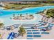 Wide aerial view of a beautiful lagoon with an island, palm trees, and beach loungers at 8296 Olive Brook Dr, Wesley Chapel, FL 33545
