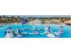 Aerial view of a vibrant water park with an inflatable obstacle course, slides, and a sandy beach at 8296 Olive Brook Dr, Wesley Chapel, FL 33545