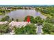 An aerial view of the property and lake, surrounded by lush trees and ample parking at 8576 Sandy Beach St, Tampa, FL 33634