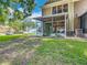 Home's backyard with enclosed patio, green grass, and AC unit at 8576 Sandy Beach St, Tampa, FL 33634