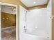 A full white tile shower and tub combo adjoin the main bedroom at 8576 Sandy Beach St, Tampa, FL 33634