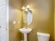A well-lit half-bathroom features a pedestal sink and ceramic toilet at 8576 Sandy Beach St, Tampa, FL 33634
