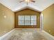 Bedroom with vaulted ceiling, three large windows, and a ceiling fan at 8576 Sandy Beach St, Tampa, FL 33634