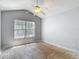 A cozy bedroom with a ceiling fan and plenty of natural light from the large window at 8576 Sandy Beach St, Tampa, FL 33634