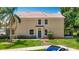 Two-story home featuring a green front door, large windows, and lush landscaping at 8576 Sandy Beach St, Tampa, FL 33634