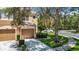 Inviting townhome showcasing a two-car garage, lush lawn, and a sidewalk nearby at 8576 Sandy Beach St, Tampa, FL 33634