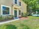 Side view of a two story home with a green door and a well maintained lawn at 8576 Sandy Beach St, Tampa, FL 33634