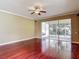 Bright living room with hardwood floors and ceiling fan; sliding door to screened in porch at 8576 Sandy Beach St, Tampa, FL 33634