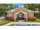 Charming pool entrance with decorative architectural details, complemented by colorful landscaping and a secure gate at 8576 Sandy Beach St, Tampa, FL 33634