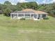Expansive backyard featuring a screened-in pool, lush lawn, and mature trees at 8827 Scout Lake Ct, New Port Richey, FL 34654
