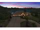 Stunning lakefront home at twilight with lush landscaping, circular driveway, and a spacious three-car garage at 8827 Scout Lake Ct, New Port Richey, FL 34654