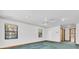 Bright room with view of yard through windows, ceiling fan, and carpeting at 8827 Scout Lake Ct, New Port Richey, FL 34654