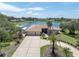 Beautiful lakefront home featuring a circular driveway, mature landscaping, and an oversized three-car garage at 8827 Scout Lake Ct, New Port Richey, FL 34654