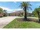 Charming home boasting a three-car garage, beautiful lawn, and mature palm tree landscaping at 8827 Scout Lake Ct, New Port Richey, FL 34654