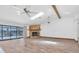 Bright open-concept living room featuring a stone fireplace, wood floors, and sliding glass doors to the pool at 8827 Scout Lake Ct, New Port Richey, FL 34654