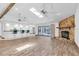 Open living space with wood floors, stone fireplace, bar seating, and sliding glass doors to pool at 8827 Scout Lake Ct, New Port Richey, FL 34654