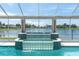 Beautiful screened pool with glass waterfall feature and lake view at 8827 Scout Lake Ct, New Port Richey, FL 34654