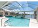 Stunning screened pool and lake view with a glass fountain at 8827 Scout Lake Ct, New Port Richey, FL 34654