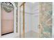 Bathroom with a shower featuring glass door, gold trim and decorative wallpaper at 8827 Scout Lake Ct, New Port Richey, FL 34654