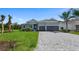Single-story home with manicured lawn, grey stucco, a 2-car garage, and decorative stone accents at 9295 Rosebud Cir, Port Charlotte, FL 33981