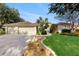 Charming single-story home with a lush lawn, palm trees and a three-car garage at 9408 Sayre St, Riverview, FL 33569