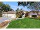 Charming home exterior with a manicured lawn, mature palm trees, and a spacious three-car garage at 9408 Sayre St, Riverview, FL 33569