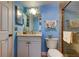 Cozy blue bathroom with vanity, modern lighting, and walk-in shower at 9484 Tara Cay Ct # 8, Seminole, FL 33776