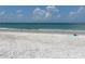 Calm ocean waves meet the soft white sand, with a beach towel inviting relaxation and peaceful views at 9484 Tara Cay Ct # 8, Seminole, FL 33776