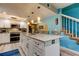 Kitchen island with seating and views of the open concept living area, staircase, and kitchen at 9484 Tara Cay Ct # 8, Seminole, FL 33776