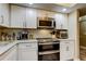 This well-lit kitchen features stainless steel appliances, and white cabinets at 9484 Tara Cay Ct # 8, Seminole, FL 33776
