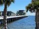 Scenic view of a pier extending into the ocean, framed by palm trees and featuring modern architecture at 9484 Tara Cay Ct # 8, Seminole, FL 33776