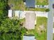 Aerial view of a home with a pool, shaded patio, storage shed, driveway, and well-maintained lawn at 1005 Monroe St, Plant City, FL 33565